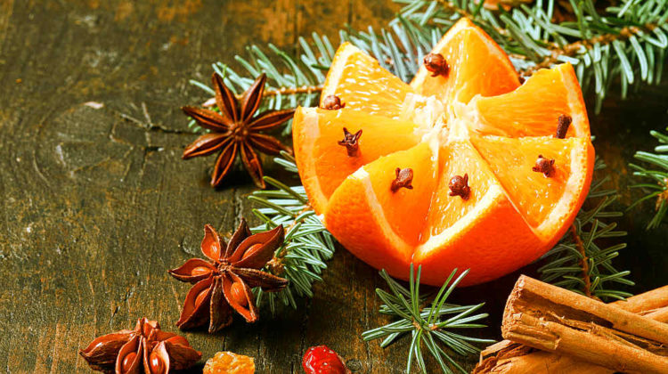 Festive Christmas background with a fresh orange cut in a fancy pattern studded with cloves | Ways To Make Your Home Smell Like Christmas | How to Make Your Home Smell Nice | fresh smelling home tips | Featured