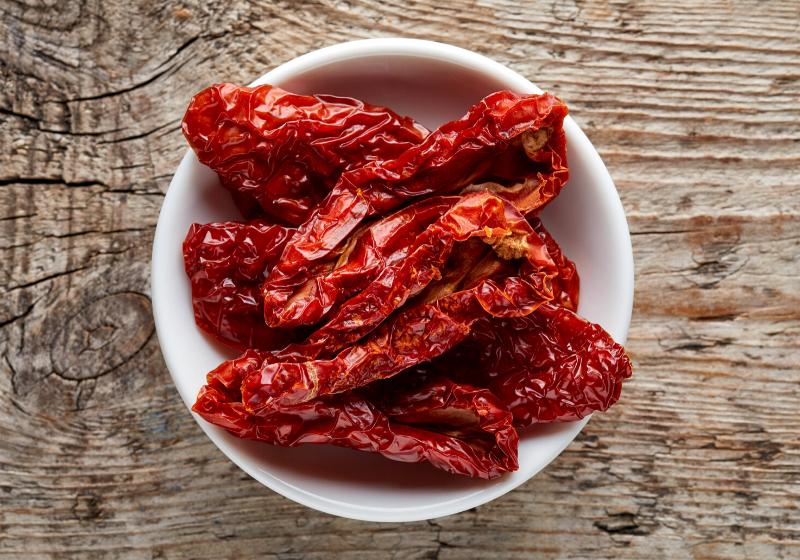 bowl sun dried tomatoes on wooden | how long does dehydrated fruit last