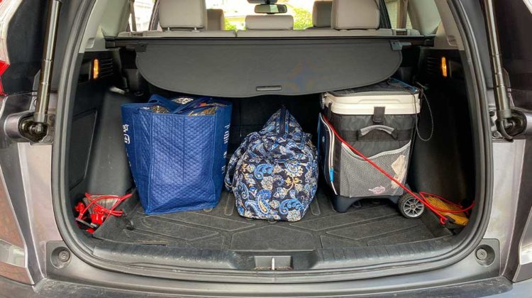 A car trunk packed with a suitcase and cooler ready for a road trip | Car Survival Kit: Must Have Winter Survival Items You Need | featured