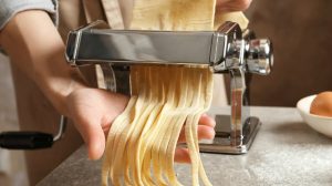 Feature | Young woman preparing noodles with pasta maker at table | Hand-Powered Tools & Appliances | The Power Of Primitive Tools