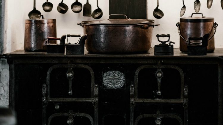 Old fashioned kitchen with copper pots | The Benefits of Using A Wood Burning Stove On Your Homestead