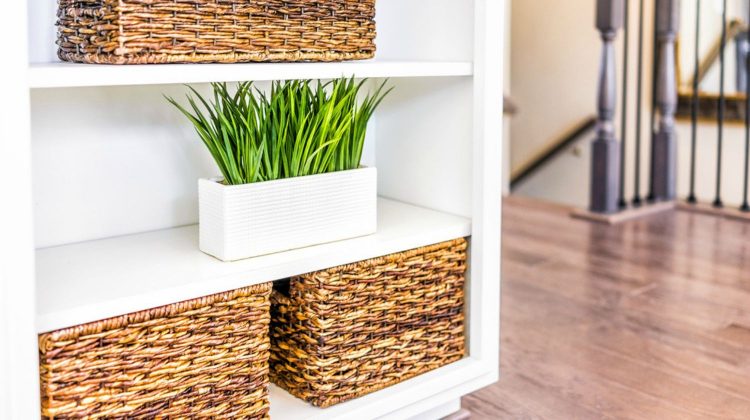 Featured | Closeup of white, modern, minimalist shelves in kitchen or living room with woven baskets and green plants pots, containers | Extra Space Storage Ideas | Make Your Space Work For You