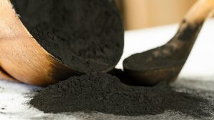 Featured | Activated Charcoal Powder Spilling Out of a Wooden Bowl | Effective Uses of Activated Charcoal