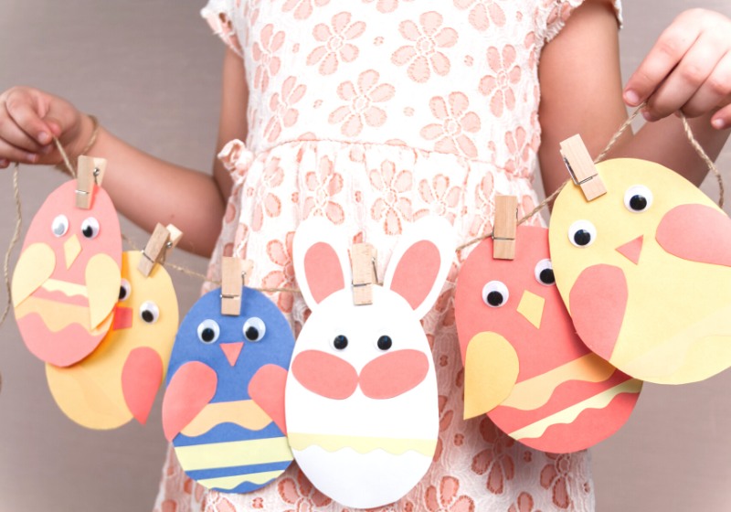 little girl holds easter paper garland | easter crafts for babies