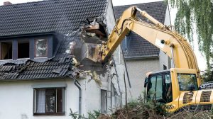 A digger demolishing houses for reconstruction | Eminent Domain: How It Is Affecting And Afflicting Homesteaders