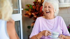 Old friends laughing together and having tea | Natural Ways To Boost Your Mood