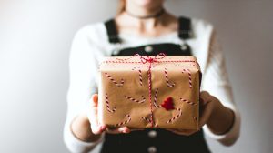 tilt-shift lens photography of woman holding candy cane-print gift box in a well-lit room | Tips For A No-Stress Homemade Holiday | homemade holiday | handmade gift ideas for friends | Featured