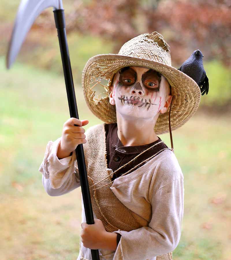 A young child is dressed in a scary Scarecrow halloween costume | scary costume