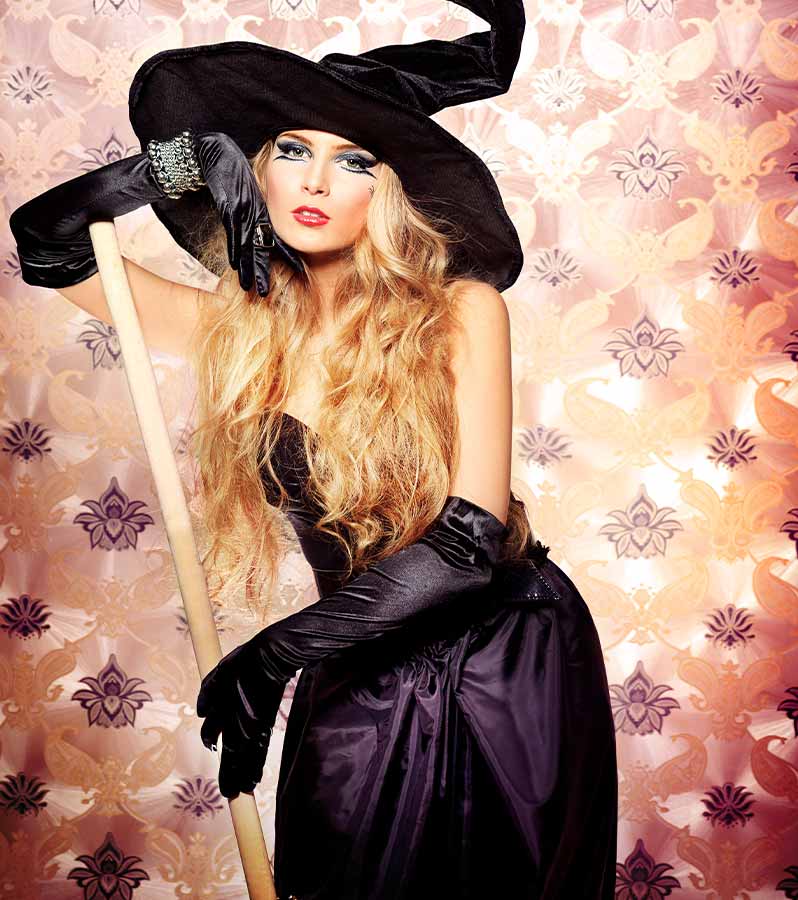 Charming halloween witch over vintage background | classic halloween costumes