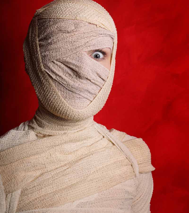 wide-eyed female mummy covered in bandages | scary costumes
