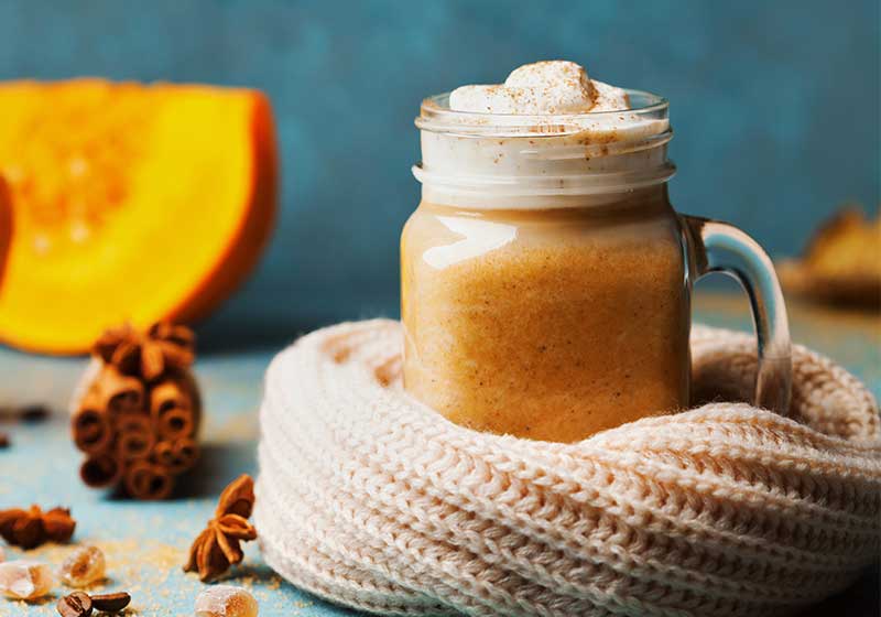 Pumpkin spiced latte or coffee in glass decorated knitted scarf | pumpkin recipe