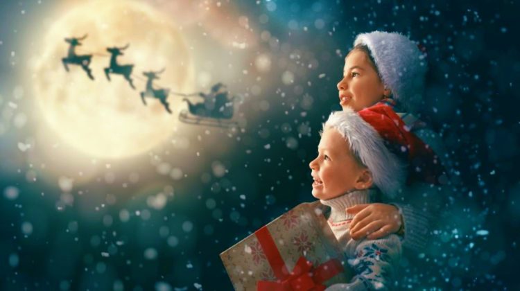 Cute little children with xmas presents. Santa Claus flying in his sleigh against moon sky | Christmas Reindeer: Everything You Need To Know About The History of Santa’s Reindeer | Christmas reindeer | reindeer names song | Featured