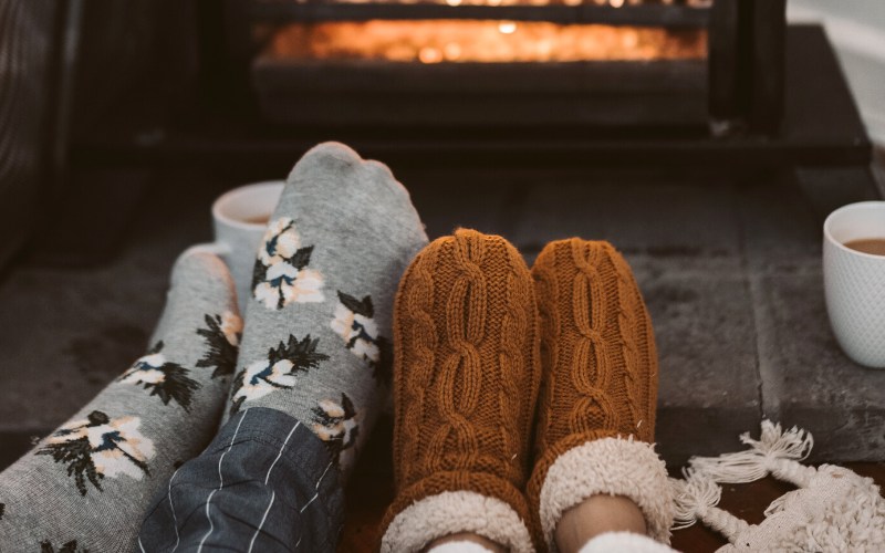 person wearing gray and white socks near brown fireplace | winter storm preparedness