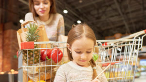 Warm-toned portrait of family doing grocery shopping in supermarket | How To Save Money On Groceries While Homesteading | grocery shopping on a tight budget | Featured