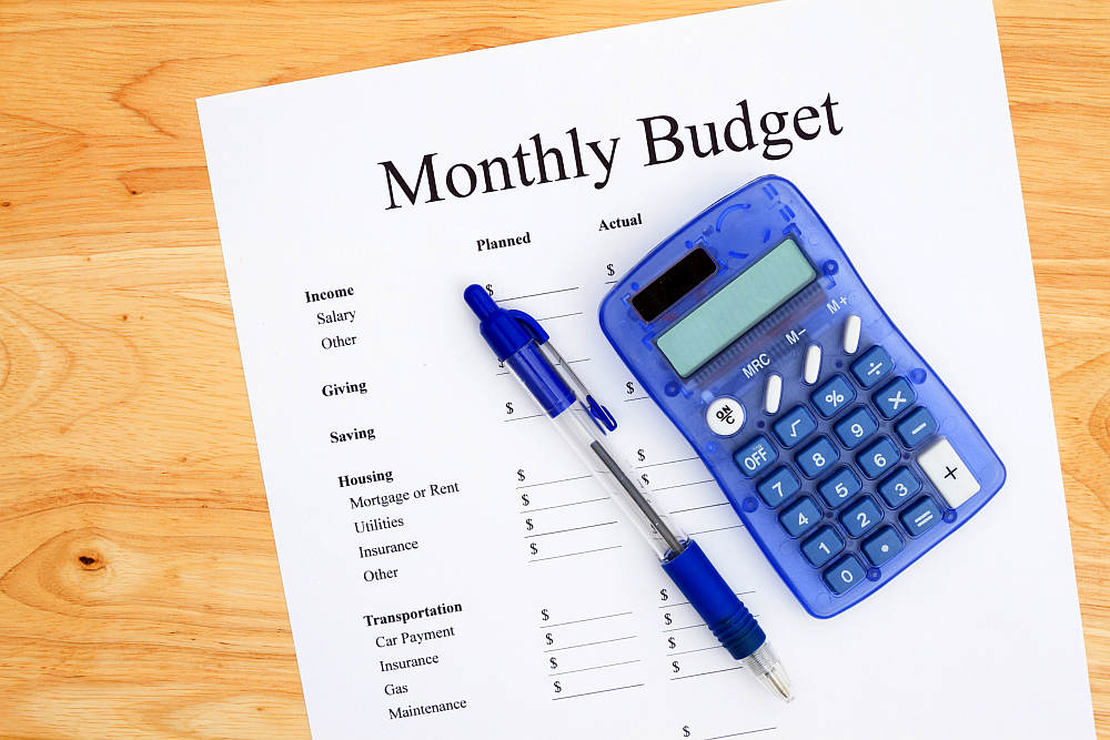 A print out of a monthly budget with pen and calculator on a desk | How To Save Money (Fast and Easy Ways) | Homesteading Basics