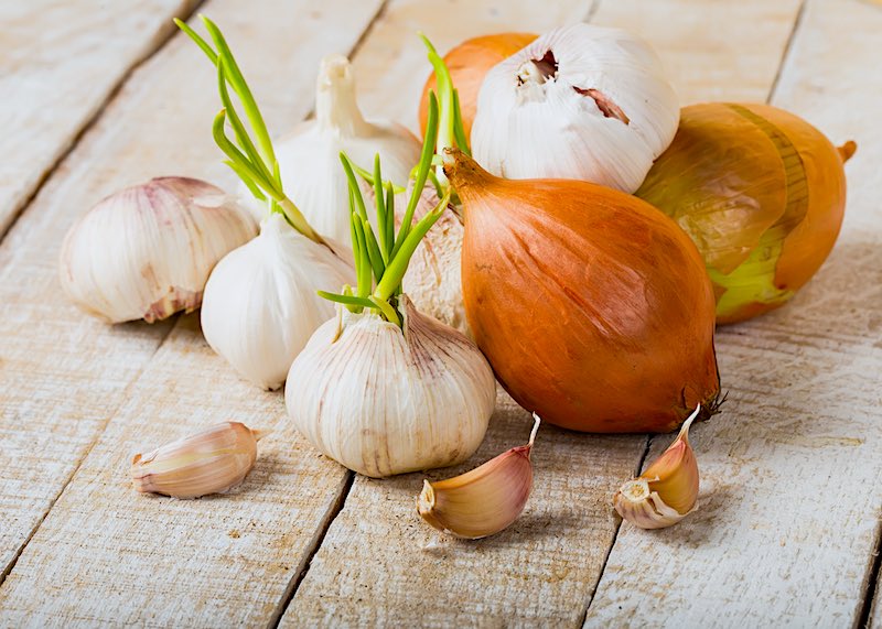 Garlic and onion on wooden background | Homemade Organic Insecticides For Homestead Farming