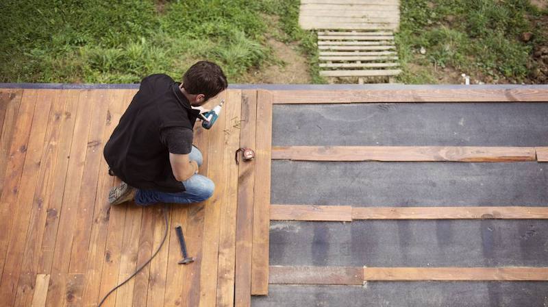 handyman installing wooden flooring on patio | Homesteading Activities You Should Do This Spring | spring activities | spring break activities