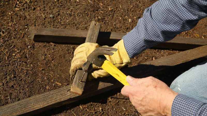 person using hammer to fix garden | Homesteading Activities You Should Do This Spring | spring activities | spring activities for toddlers