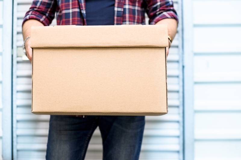 young-man-holding-moving-cardboard-box| Fall Home Maintenance Checklist: How To Prepare Your Home For Fall