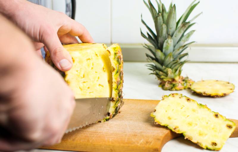 male-hands-peeling-fresh-pineapple-skin | A Homesteader’s Guide To Canning Pineapple | mason jar