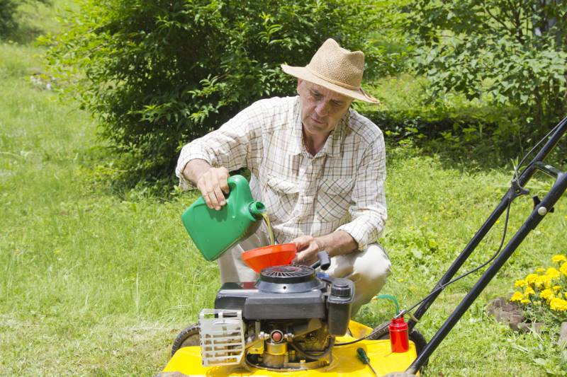 mid age man adding oil lawn | Lawn Mower Repair: Common Problems And How To Fix Them