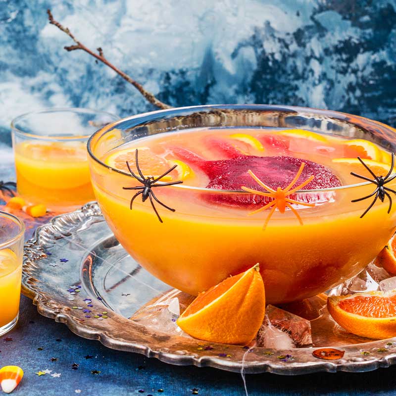 Ghoul's orange punch with bloody ice hand in a glass bowl | cocktail recipes