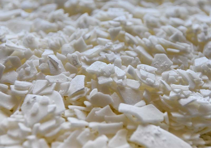 Close up of white soy wax flakes for candle making in a ceramic bowl | Candle Making Supplies Guide