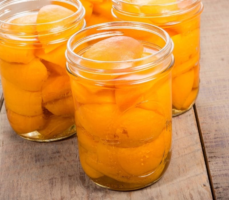 Small mason jars of sliced fresh yellow peaches | peach