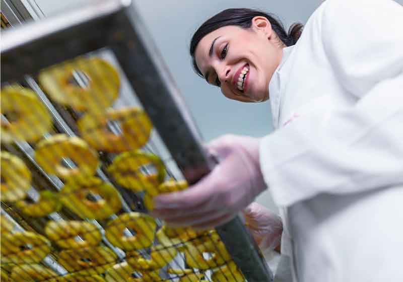smiling female food technician working on | dried fruit