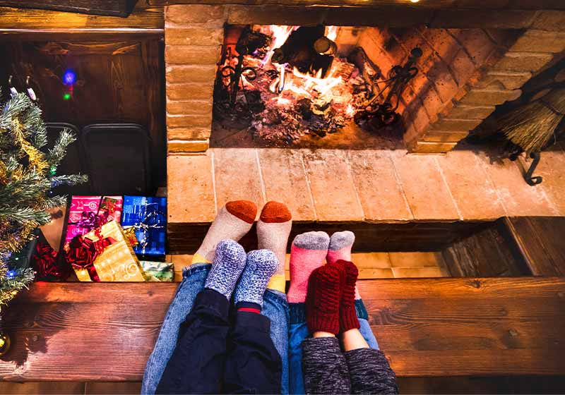 Mother father and kids sitting at cosy fireplace on winter time | snow hacks