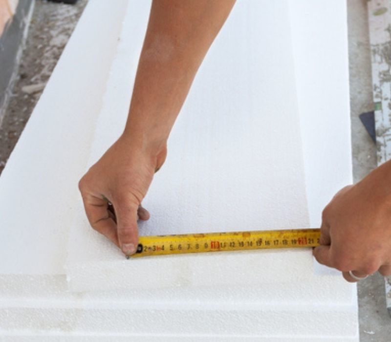 Worker use ruler to measure the correct length of styrofoam | solar stock tank heater