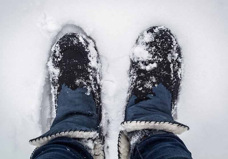 man's feet in the snow in wet shoes | winter hacks for home