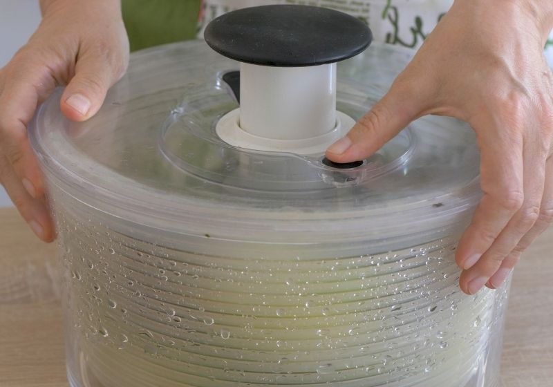 Woman drains lettuce from the water in a salad spinner  | How to freeze rhubarb 