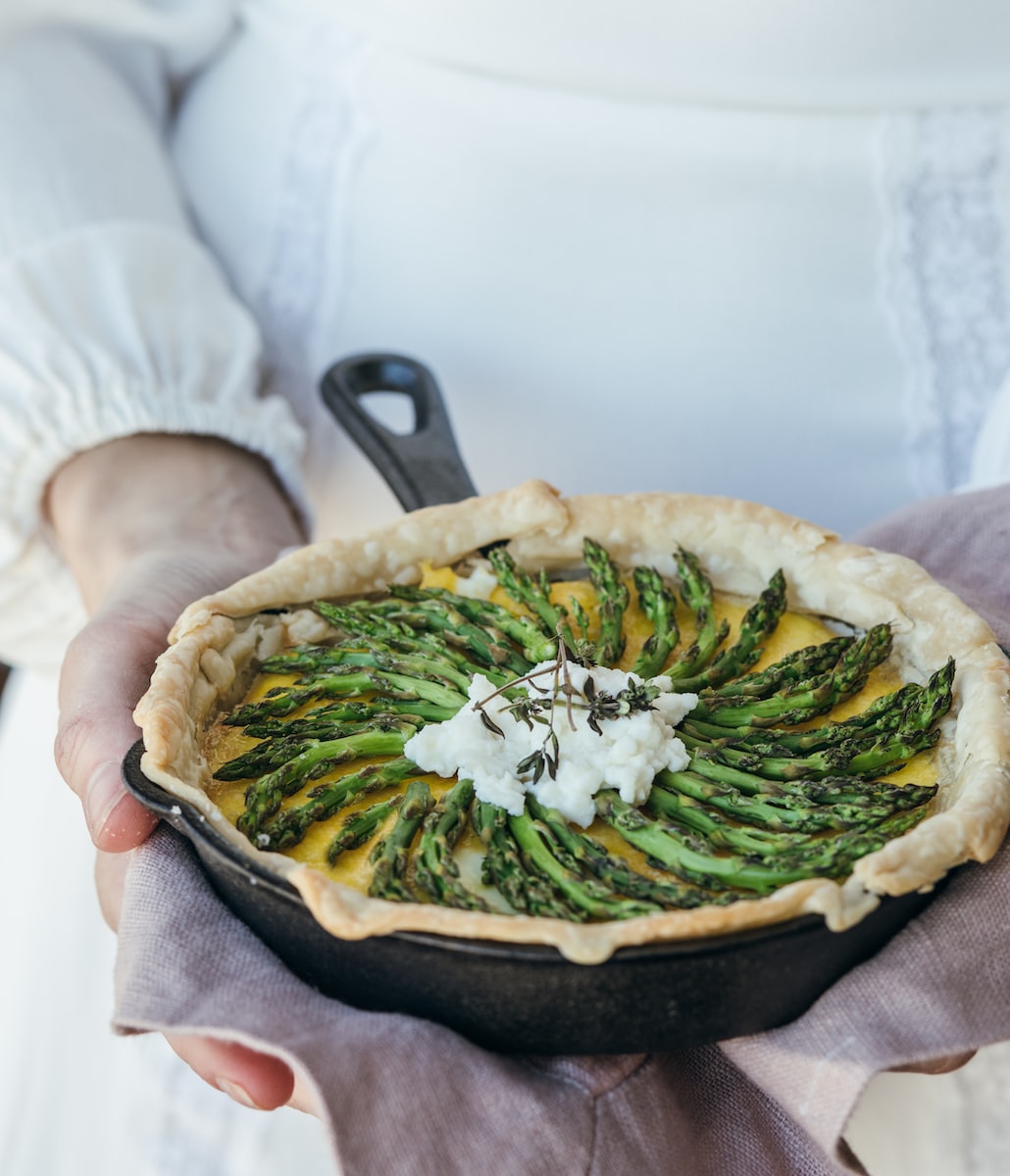 Asparagus Quiche person holding cooked food in cooking pan