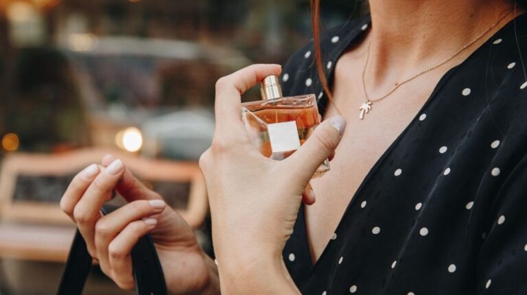 Fashion blogger posing with perfume outdoors | How To Make Perfume | Featured