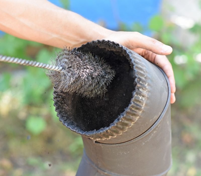 Man cleaning chimney pipe | how to clean a chimney