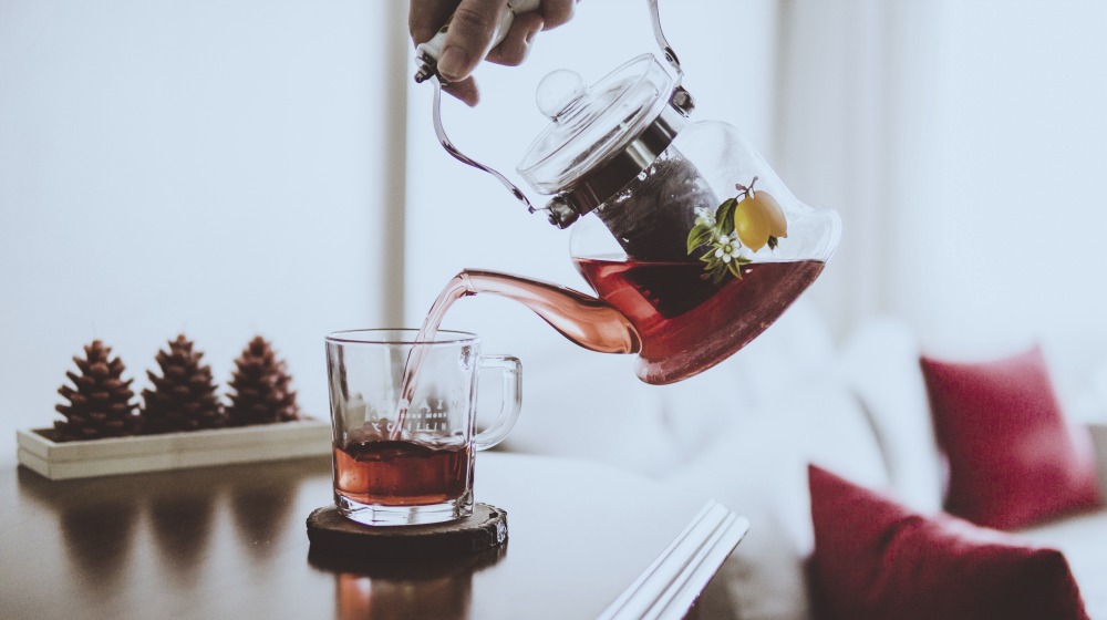 person holding teapot pouring up on glass mug | Tips For A No-Stress Homemade Holiday | homemade holiday | creative homemade gifts