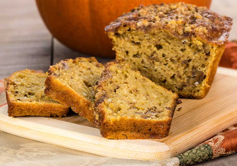 Pumpkin walnut bread freshly made on bamboo cutting board | fall recipe