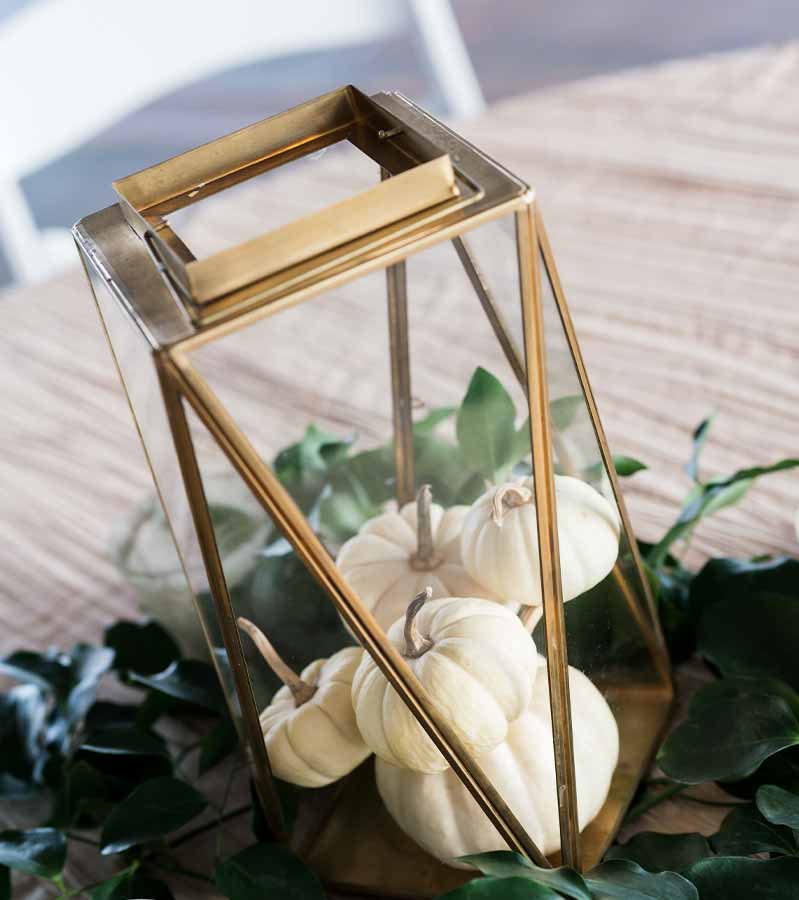 Tabletop centerpieces at wedding reception utilizing glass vase and small white pumpkins | thanksgiving centerpiece