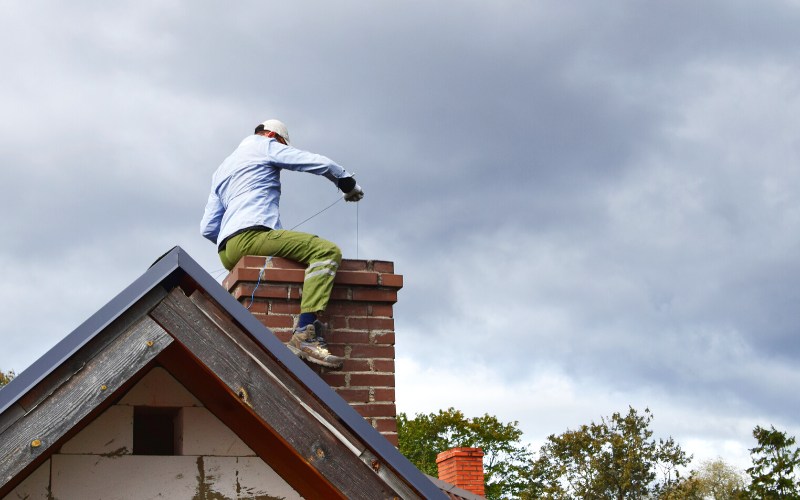 chimney sweep man cleaning brown brick | blizzards