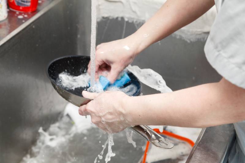 closeup-dishwasher-uniform-washes-griddle-foam | How To Season A Cast-Iron Griddle