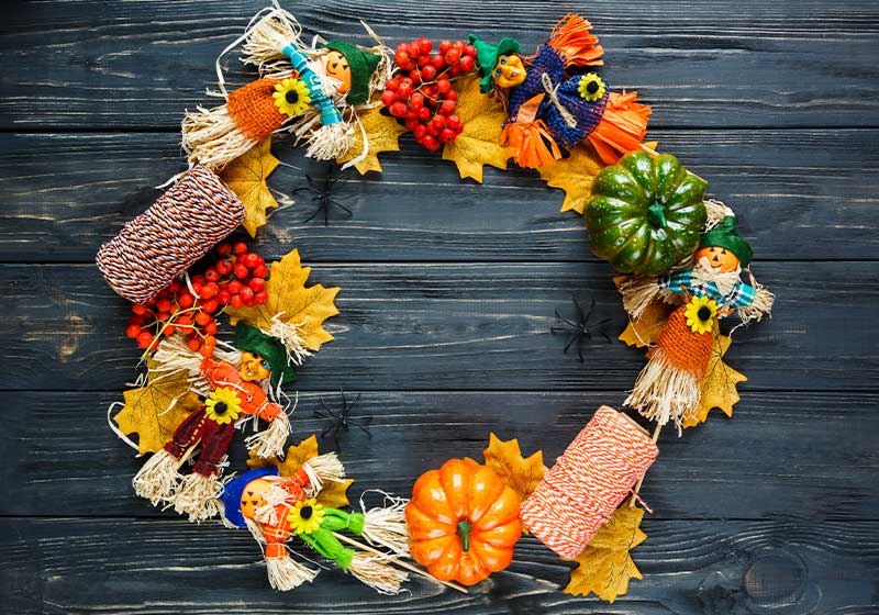 colorful wreath with pumpkins, leaves, rowan, ropes, scarecrows | scarecrow ideas for garden