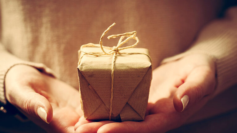 Giving a gift, handmade present wrapped in paper | Gift Ideas For Homesteading | Practical And Lovely Presents | top homesteading gifts | Featured