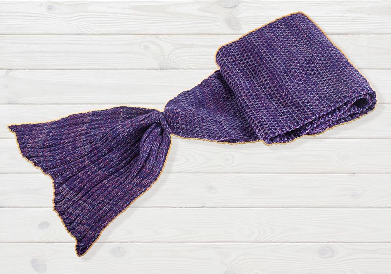isolated close up shot of a soft fluffy woollen knitted mermaid tail lap blanket | warm blankets