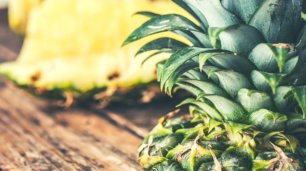 sliced pineapples on wooden board | A Homesteader's Guide To Canning Pineapples | Featured