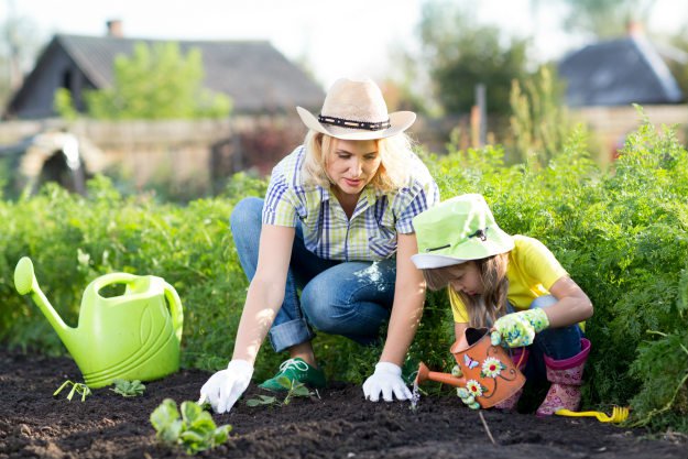 woman-working-in-garden-with-daughter Homesteads and Skyscrapers | Country Folk vs City Dwellers