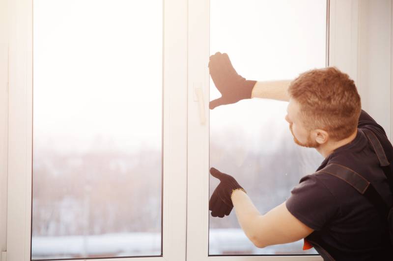 worker-man-installs-plastic-windows-doors | Fall Home Maintenance Checklist: How To Prepare Your Home For Fall